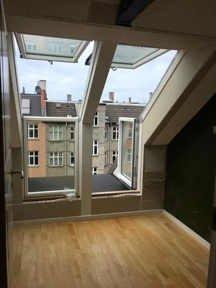 Nyindrettet tagetage med åbne Velux-vinduer og udsigt over etageejendomme